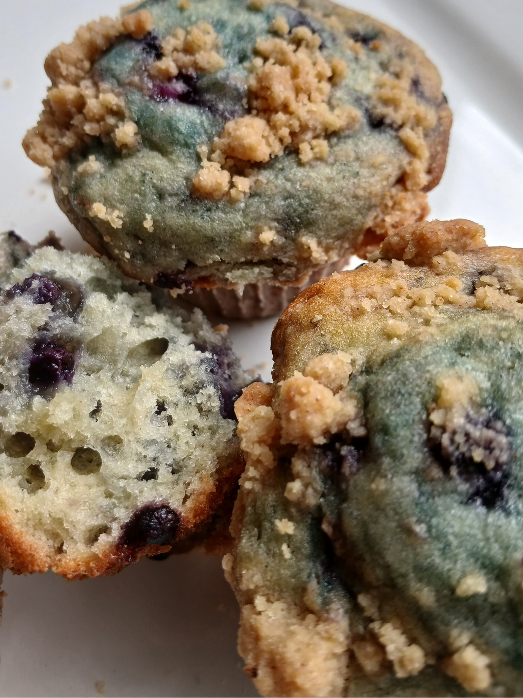 Blueberry muffins with crumb topping on a white plate